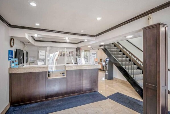 A reception area with a counter, a staircase, and a clock on the wall.