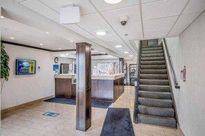 Un espace d’accueil comprenant un comptoir, une horloge et un escalier.