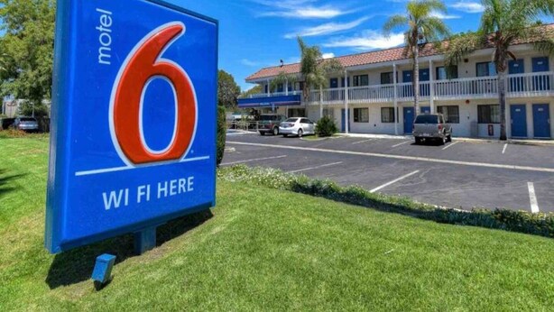 Señal de motel con el número 6 y el texto 'WI FI HERE' que indica disponibilidad de Wi-Fi.