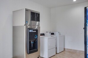 A laundry room with a water dispenser, a dryer, and a washing machine. - 1 King Bed | Non-Smoking (White House)