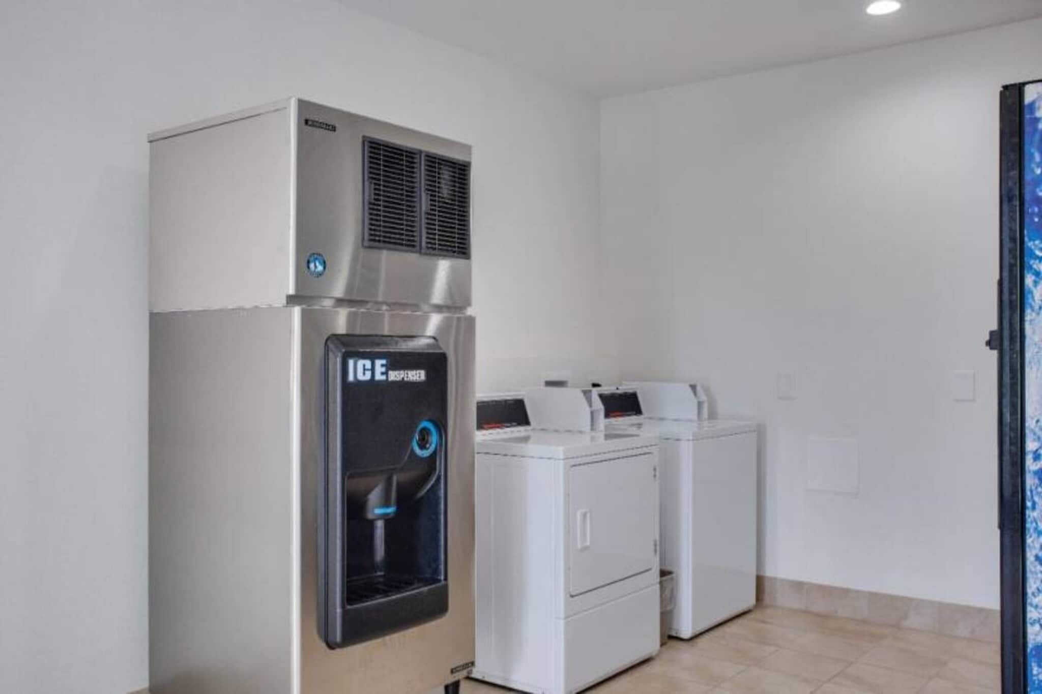 A laundry room with a water dispenser, a dryer, and a washing machine.