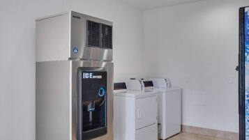 A laundry room with a water dispenser, a dryer, and a washing machine.