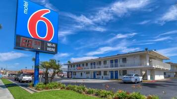A motel with a large sign indicating room number 6 and a Wi-Fi availability sign.