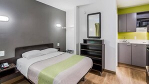 A compact hotel room with a bed, bedside table, and a small kitchenette. - Cozy King Bed|Free Wifi&Parking,TV (Jacksonville)