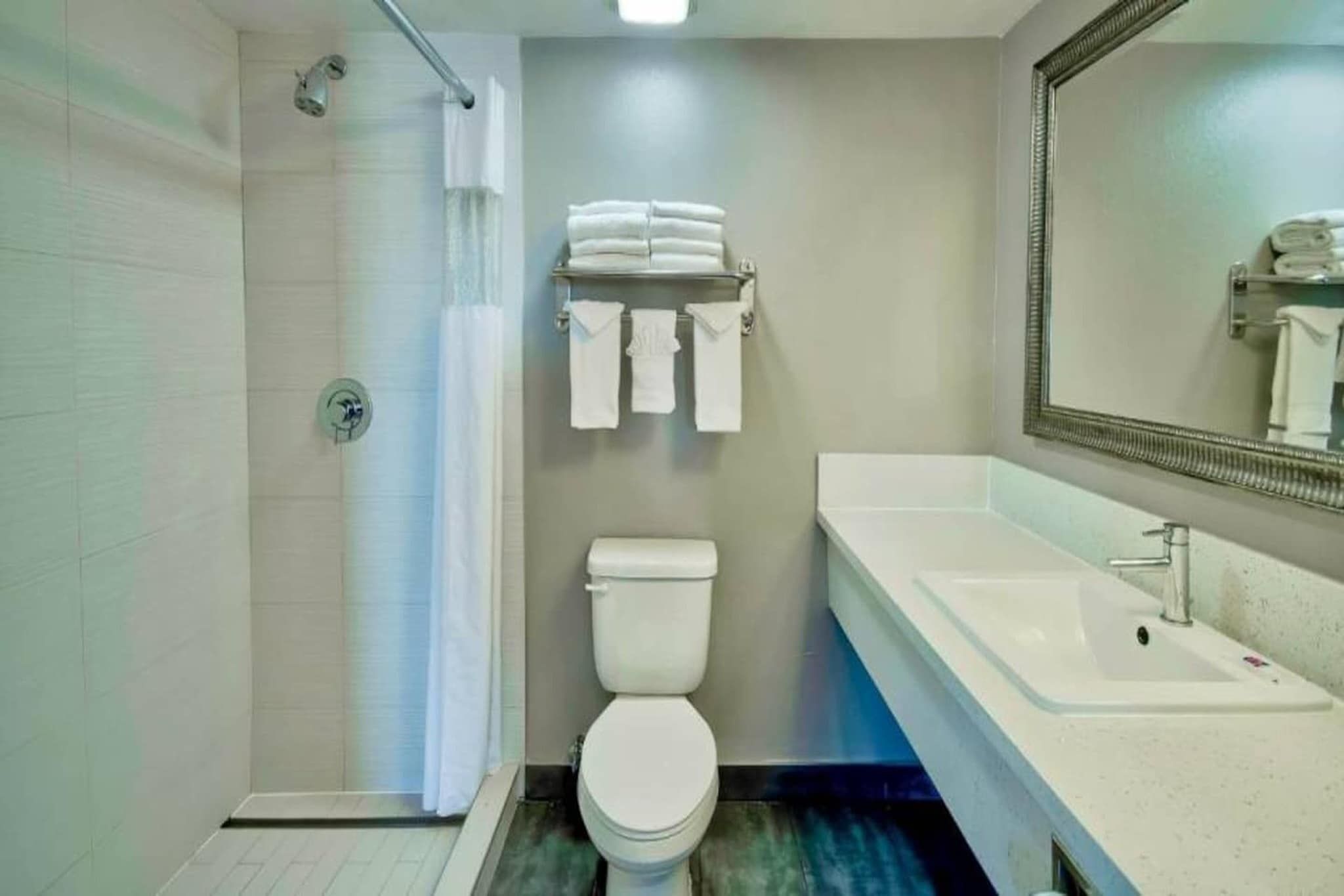 Ein Badezimmer mit Dusche, Toilette und Waschbecken.