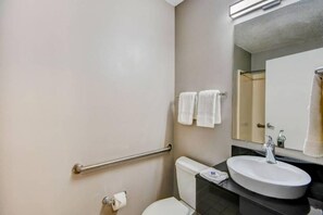 A bathroom with a toilet, sink, and handrails. - 2 Full Beds | Non-Smoking (Ocean Springs)