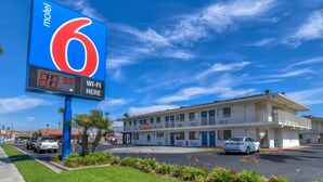 Een motel met een groot bord waarop kamer nummer 6 staat en een bord dat Wi-Fi beschikbaarheid aangeeft.