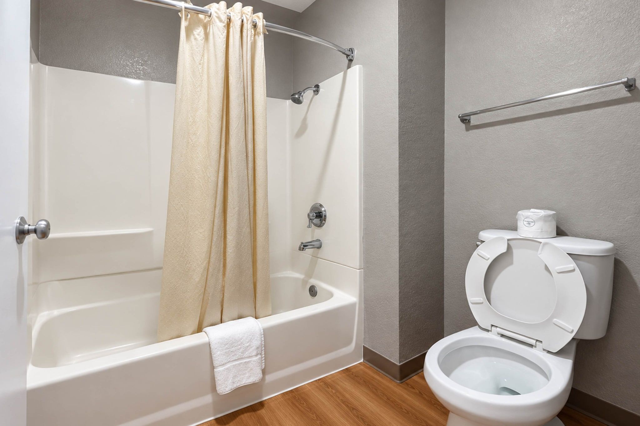 A bathroom with a bathtub, toilet, and shower curtain.
