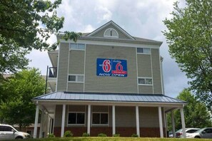 A two-story motel with a '6' logo, a covered front porch, and a 'NOW OPEN' sign. - Sunny Queen Bed Room|Pool|Free Wifi (Greensboro)