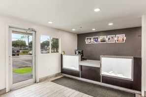 A reception area with a desk, a computer, and a door leading outside. - Spacious 2-Bed|Free Parking & Wifi (Jacksonville)