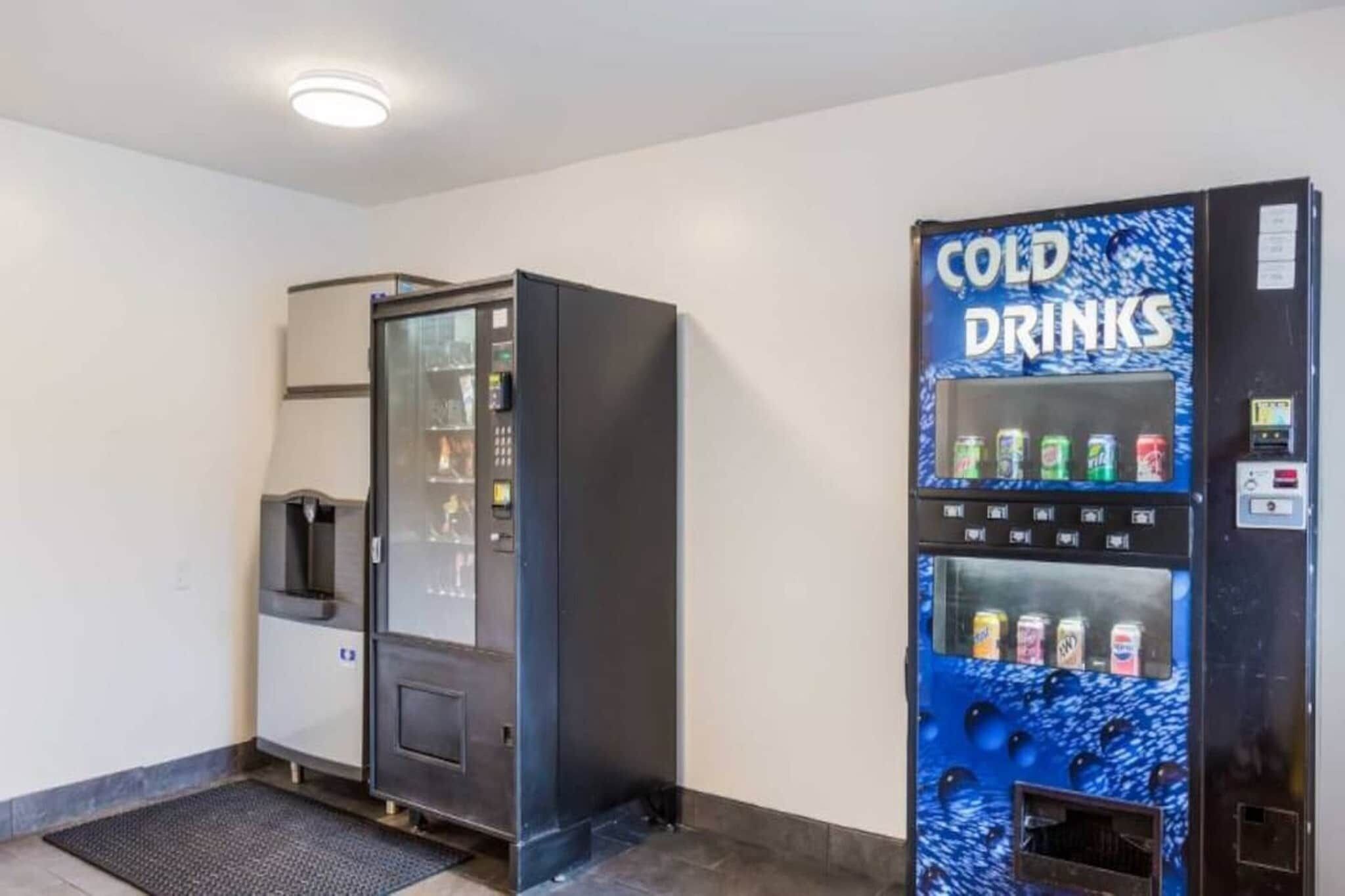 A vending machine with a blue 'COLD DRINKS' sign and a water dispenser.