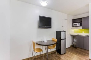 A compact kitchen with a dining table, chairs, a refrigerator, and a microwave. - Spacious 2-Bed|Free Parking & Wifi (Jacksonville)