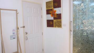 Habitación con una puerta blanca, una escalera de madera, un aviso de privacidad y una puerta de cristal con estampado floral.