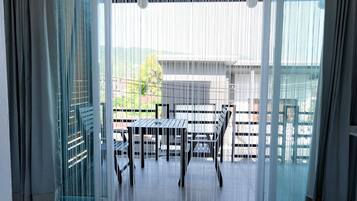 A room with a sliding glass door leading to an outdoor area with a table and chairs.