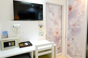 A room with a flat-screen TV mounted on the wall, a telephone with a payphone, and a small table with a tray. - Baanpoon Apartment (Koh Samui)
