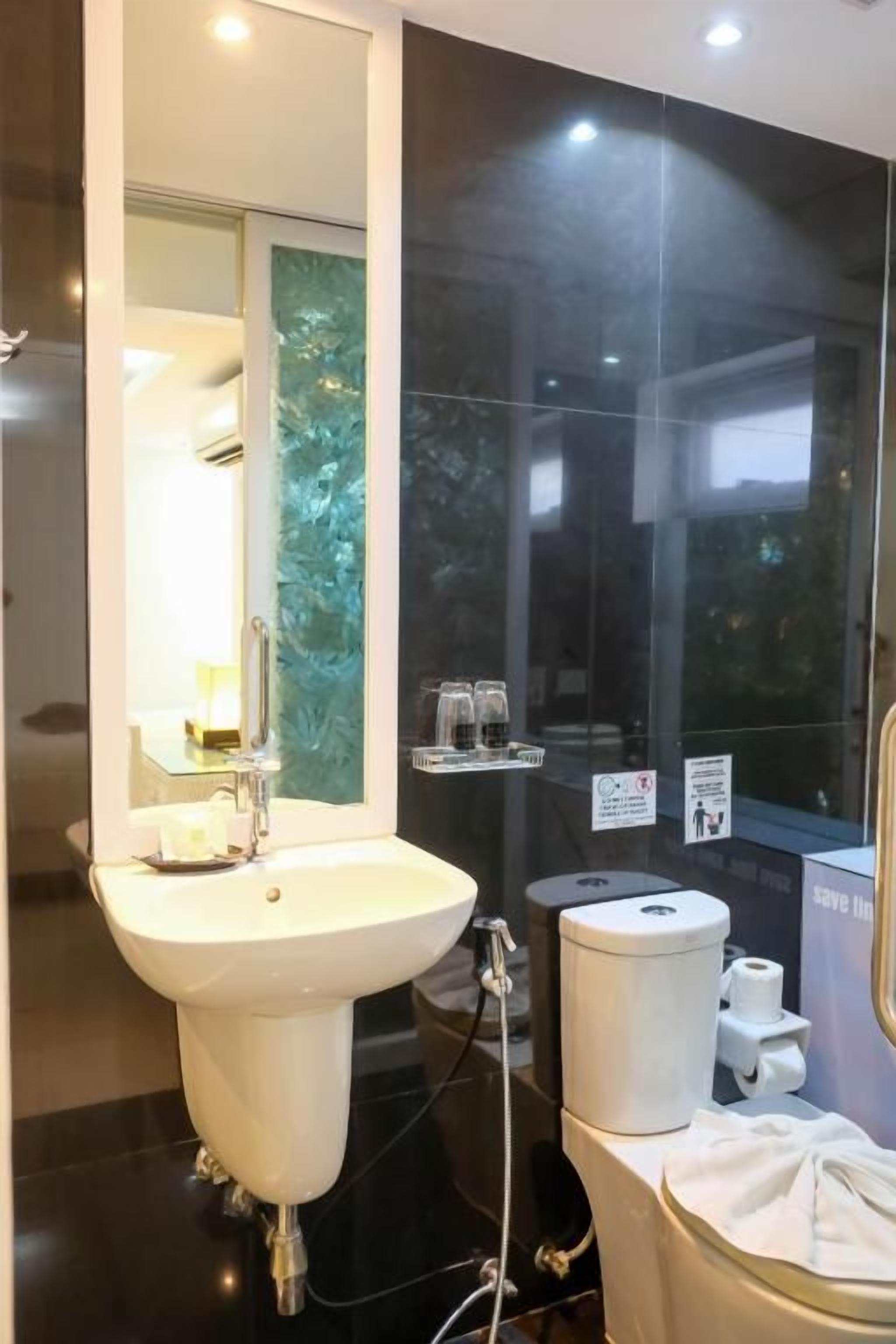 A modern bathroom with a large sink, mirror, and a glass shower enclosure.