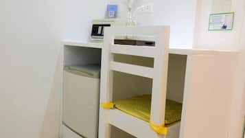 A small, enclosed space with a white chair and a white cabinet.