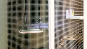 Cabina de dutxa amb porta de vidre, plat de dutxa manual i dosificador de sabó.