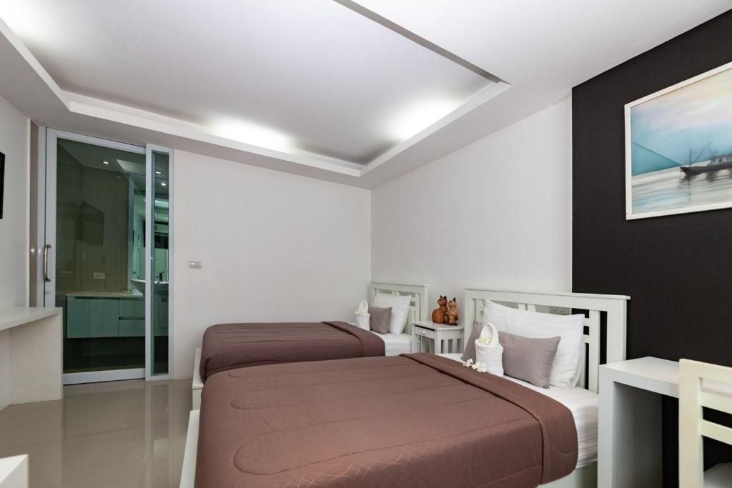 Une chambre d’hôtel moderne avec deux lits, une petite table et un tableau au mur.