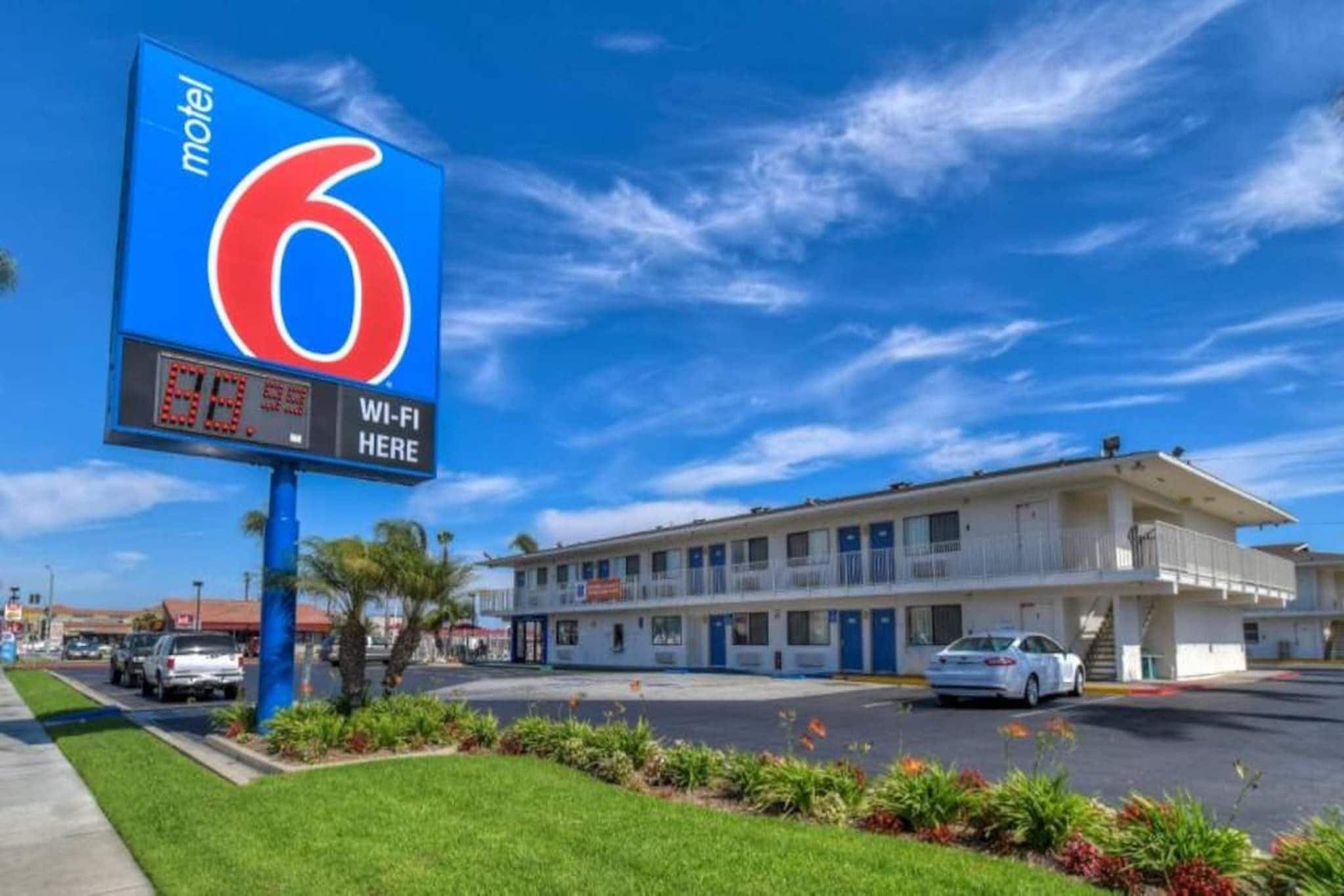 Een motel met een groot bord waarop kamer nummer 6 staat en een bord dat Wi-Fi beschikbaarheid aangeeft.