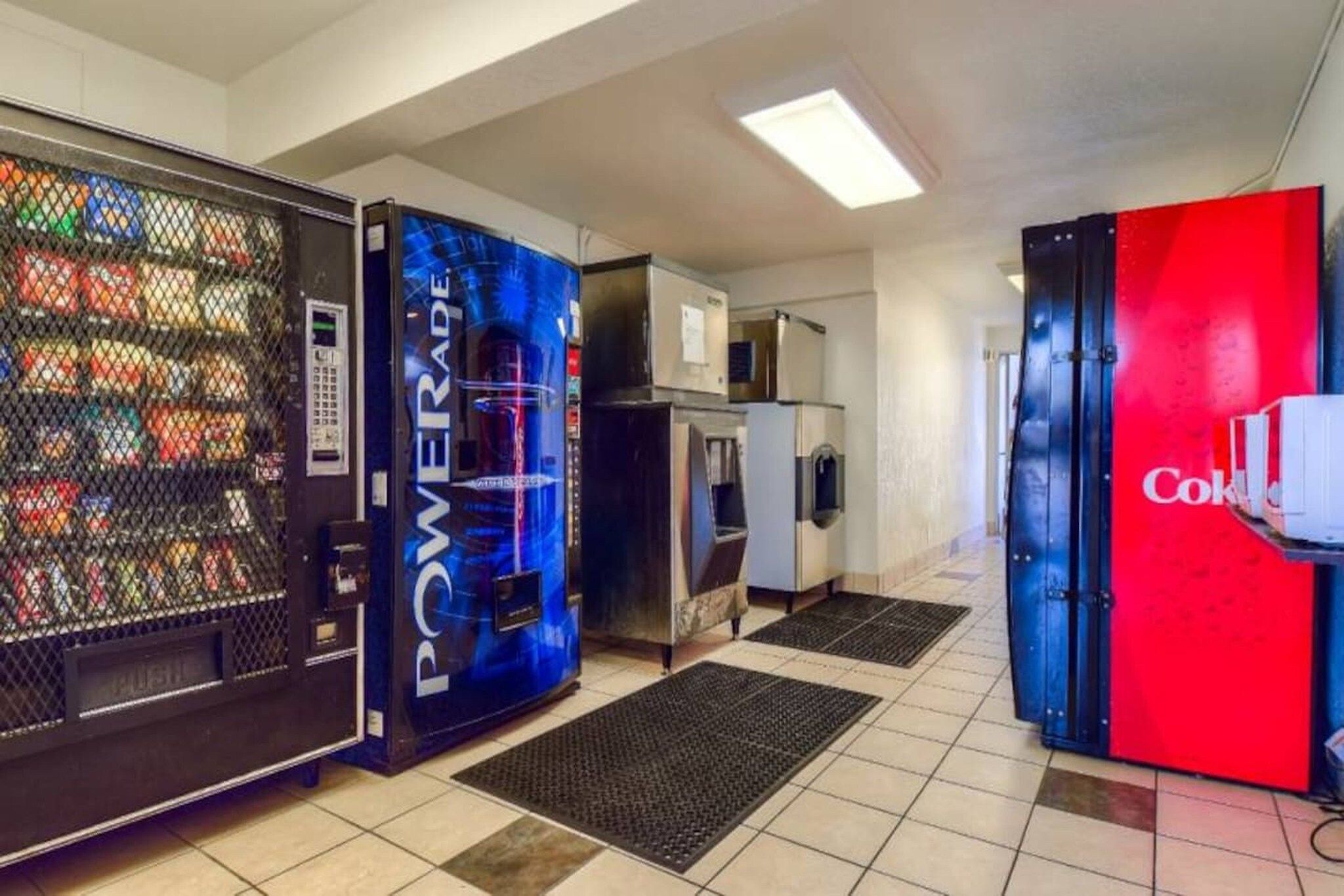 Una zona de máquinas expendedoras con refrigeradores de Powerade y Coca-Cola.
