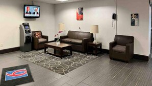 A hotel lobby with a sofa, armchairs, a coffee table, a TV, and a minibar. - 1 King Bed | Non-Smoking, Kitchen (Clarion)