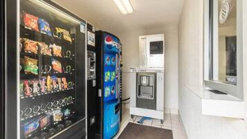 Zona de máquinas expendedoras con opciones de bocadillos y bebidas, incluyendo una máquina de Pepsi.