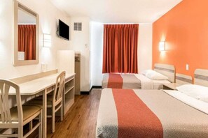 A hotel room with a desk, two beds, a television, and a window with curtains. - 2 Full Beds | Non-Smoking (Newport)