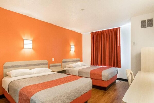 A hotel room with two beds, a desk, and a chair. - 2 Full Beds | Non-Smoking (Newport)