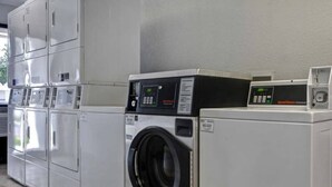 Een rij witte wasmachines in een commerciële omgeving.