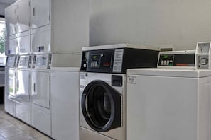 A row of white laundry machines in a commercial setting. - 1 Queen Bed | Non-Smoking, Kitchen (Jacksonville)