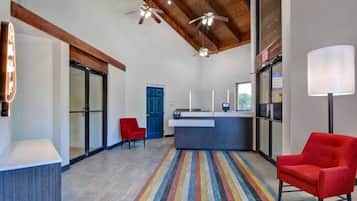 Une cuisine moderne avec un îlot central, une chaise rouge et un tapis coloré à rayures.