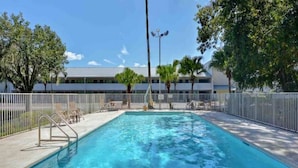 A swimming pool with a metal fence, lounge chairs, and a building in the background. - 1 King Bed|Non-Smoking,Kitchen (Jacksonville)