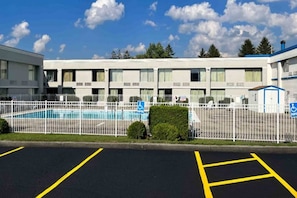 A hotel with a swimming pool, parking spaces, and a fenced area. - Studio 6 Suites Clarion, Pa_1 Queen Bed (Clarion)