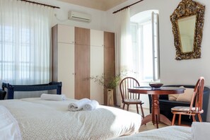 A hotel room with a bed, a desk, a chair, a wardrobe, and a mirror. - Villa Iveta - Two-bedroom Apartment With Terrace and Sea View (Dubrovnik)