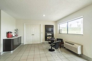 A room with a kitchenette, a dining area, and a large window. - 1 King Bed | Non-Smoking (CRAWFORDSVILLE)