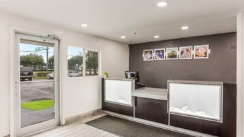 A reception area with a desk, a computer, and a door leading outside.