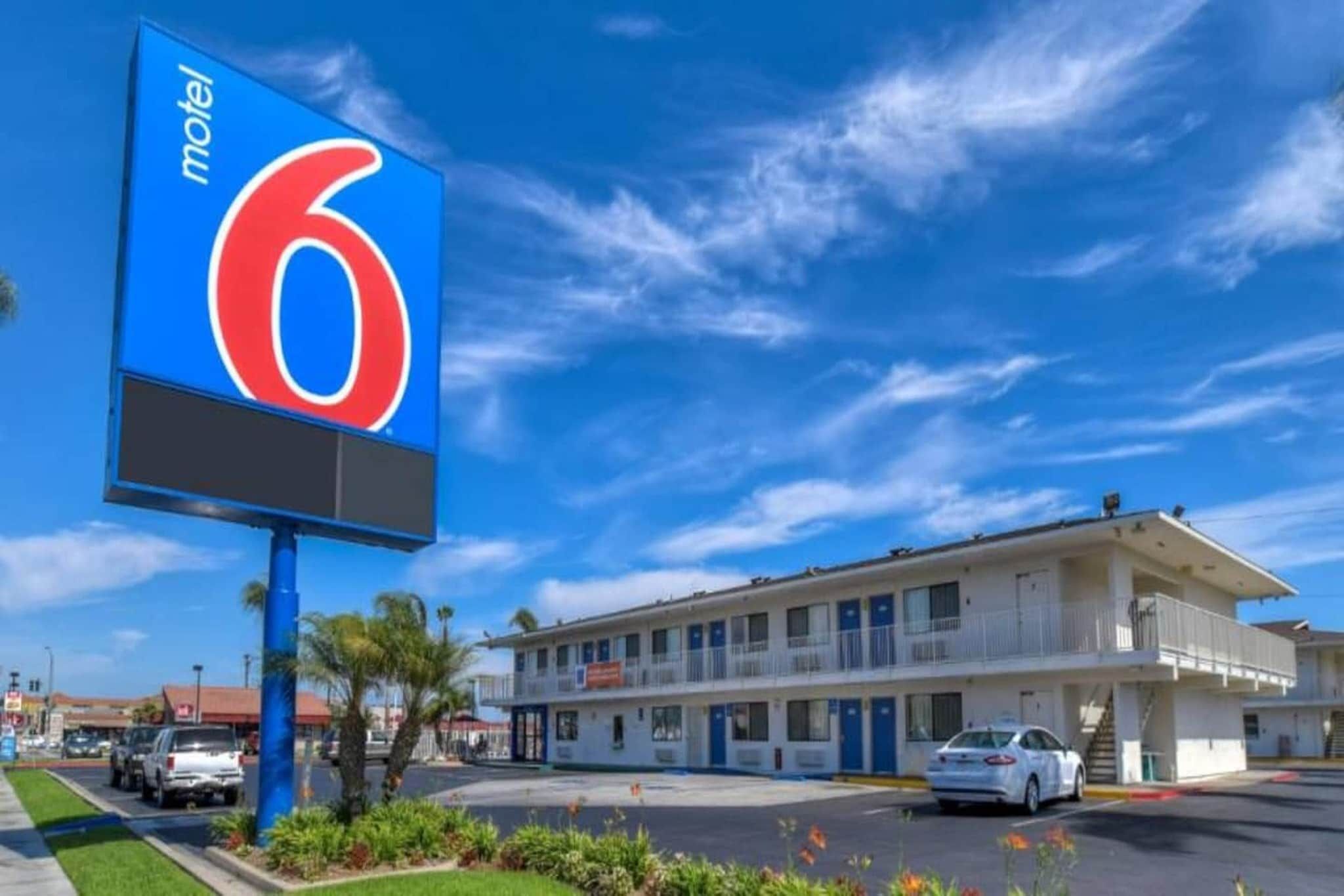 A motel with a large blue sign displaying the number 6.
