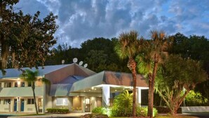A hotel with a modern design, featuring a covered entrance and a landscaped garden with palm trees. - 1 King Bed|Mobil Access Tub|Nsmk|Kitchen (Jacksonville)