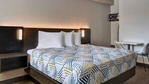 A modern hotel room with a large bed, bedside tables, a desk, and a chair. - 1 King Bed|Mobil Access Tub|Nsmk|Kitchen (Jacksonville)