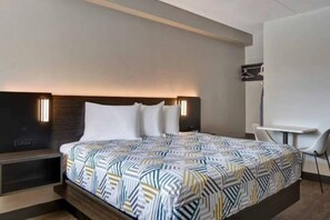 Een moderne hotelkamer met een groot bed, nachtkastjes, een bureau en een stoel.