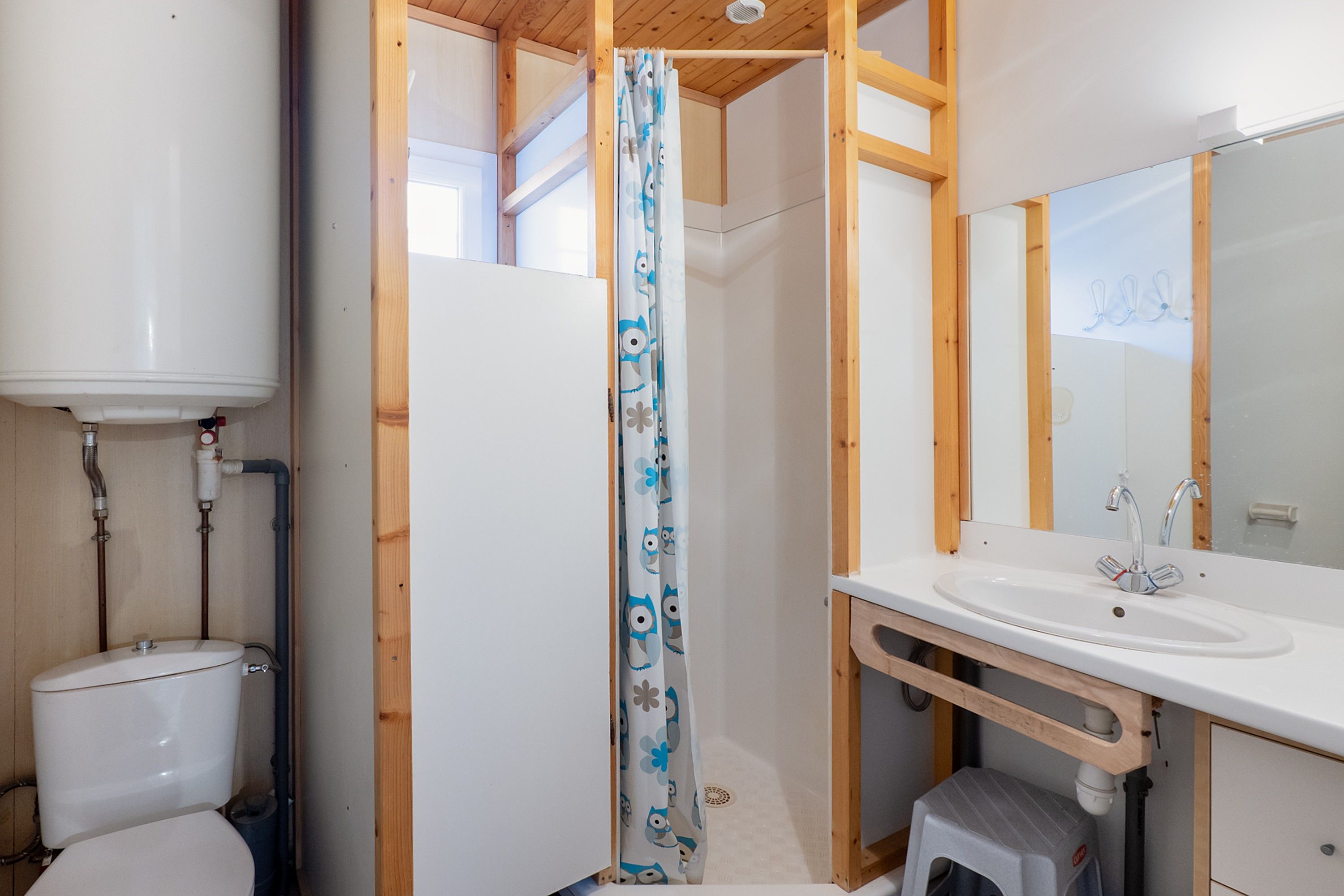 Une salle de bain avec des toilettes, un lavabo et un rideau de douche.