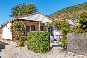 A single-story house with a sloped roof, a satellite dish, and a gravel driveway. - Chalet 'Castellane' with Mountain View, Shared Pool and Wi-Fi (Castellane)