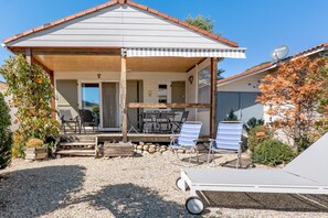 A two-story house with a covered porch, outdoor seating, and a gravel driveway. - Chalet 'Castellane' with Mountain View, Shared Pool and Wi-Fi (Castellane)