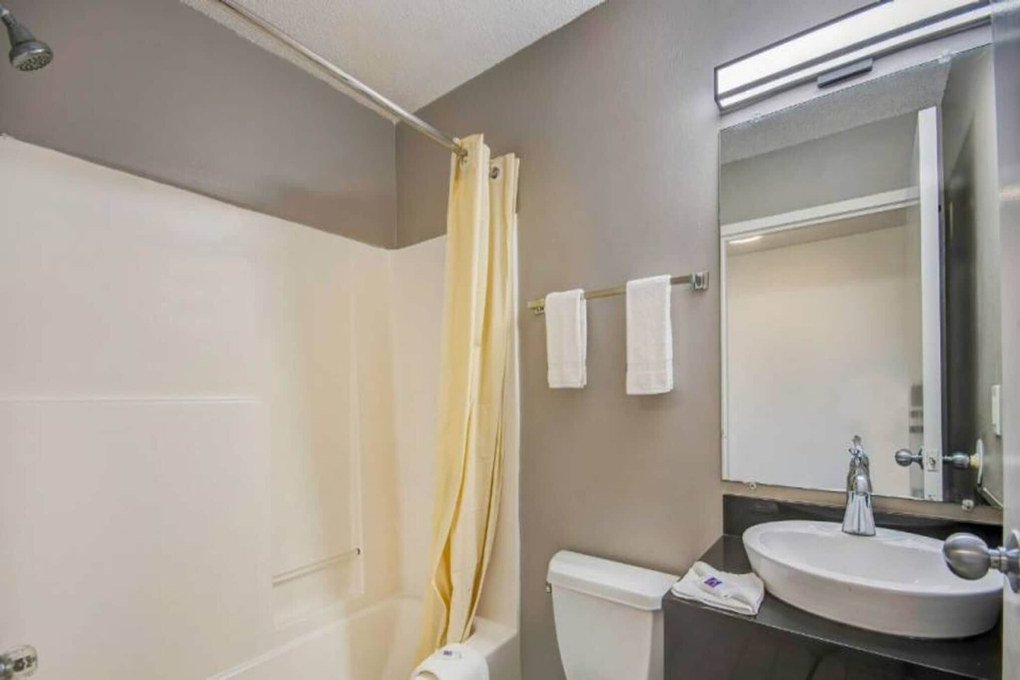 A bathroom with a bathtub, toilet, and sink.