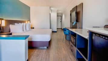 A hotel room with a bed, a desk, and a chair.