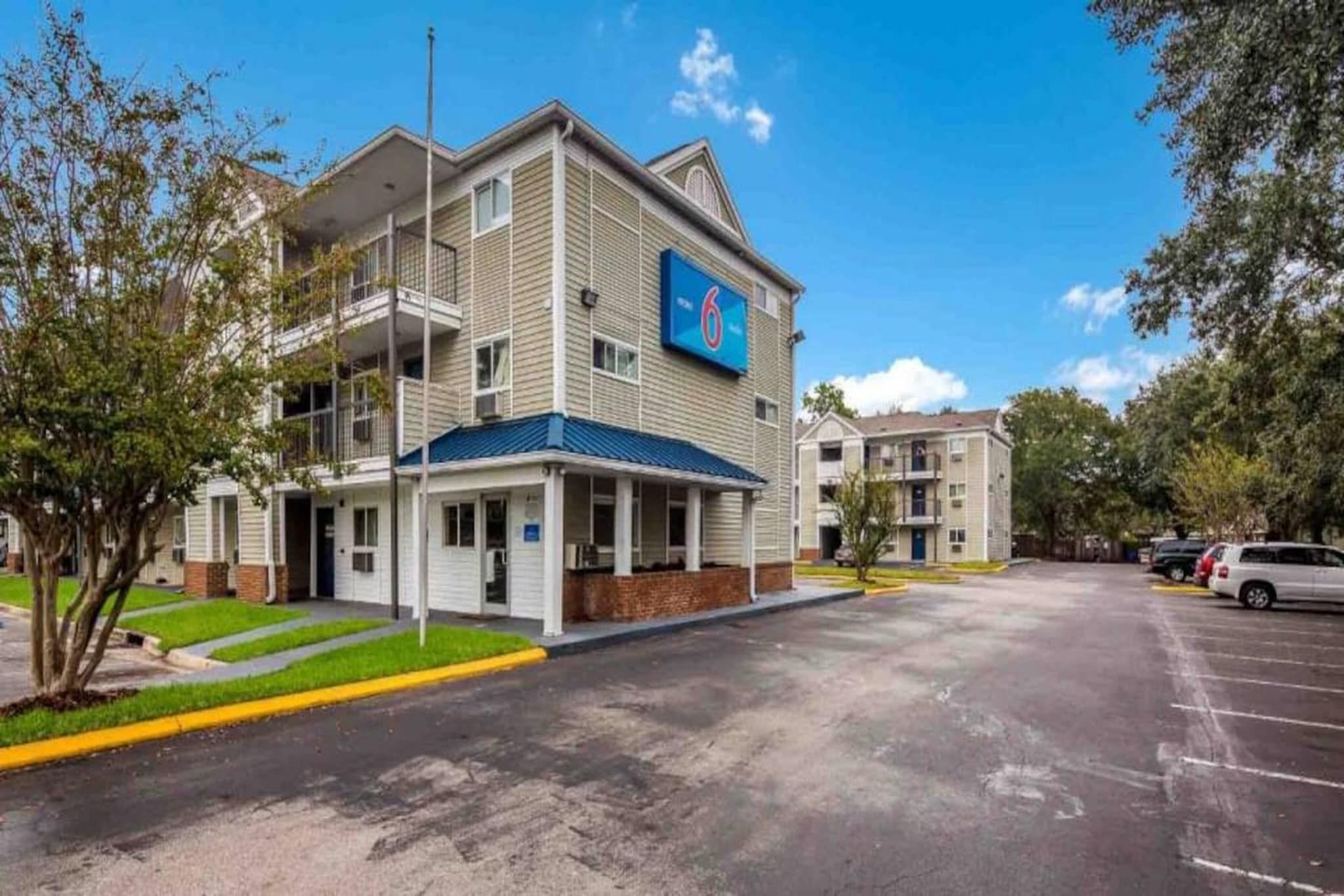 Un hôtel à plusieurs étages, reconnaissable à son panneau bleu indiquant le nombre de chambres.