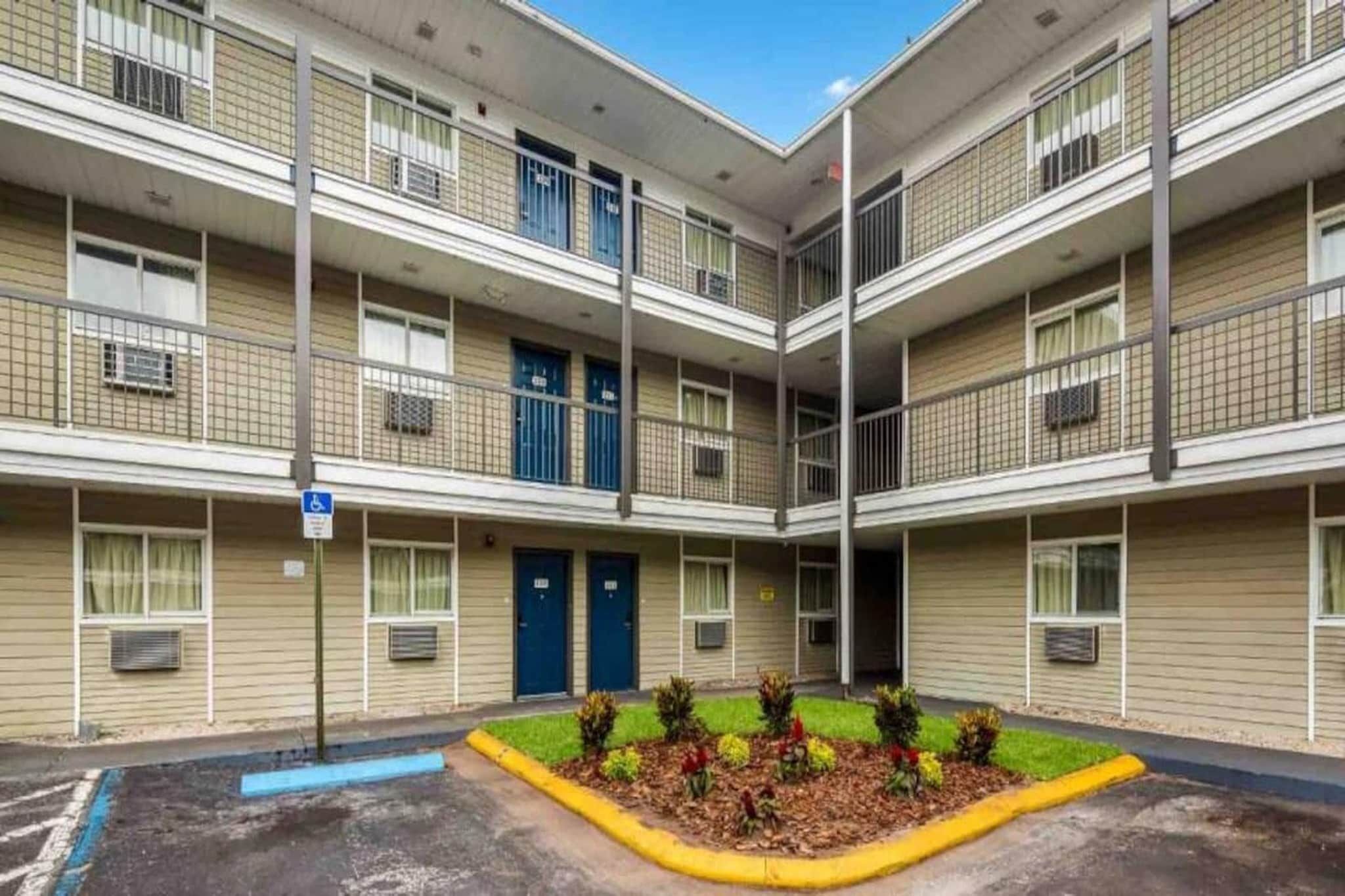 A multi-story building with a central courtyard, featuring a wheelchair-accessible entrance and multiple balconies.
