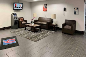 A hotel lobby with a sofa, armchairs, a coffee table, a TV, and a minibar. - 2 Full Beds | Smoking, Kitchen (Clarion)