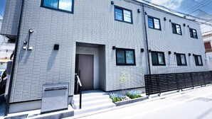 A modern hotel building with a metal facade, multiple windows, and a visible entrance. - WANOKAEDE HOTEL NEW WING (Tokyo)